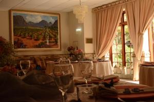 肯普顿帕克酒庄宾馆和会议中心的一间用餐室,配有酒杯和墙上的绘画