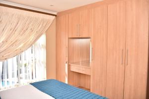 鲁德普特寄宿旅游旅馆的一间卧室配有木制橱柜和一张带窗户的床。
