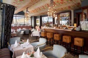卢森堡卢森堡高瑞斯集团的一间设有白色桌椅的餐厅和一间酒吧