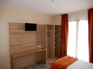 Châtillon-de-MichailleHotel Marinet的一间卧室配有一张床,墙上配有电视