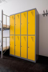 华沙Inbed Hostel的一间更衣室,配有黄色储物柜和一张双层床