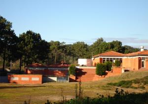 福斯·杜·阿勒奥Parque de Campismo Orbitur Foz de Arelho.的山丘上树木背景的房子