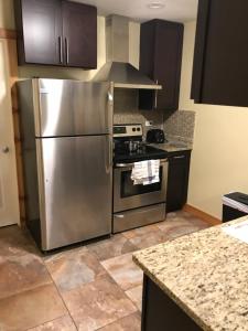 芝加哥法韦尔之梦公寓的厨房配有不锈钢冰箱和炉灶。