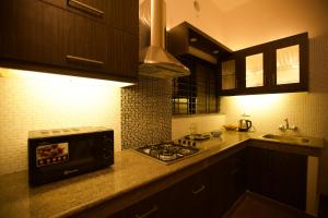 科钦Anchorage Serviced Apartments的一间带炉灶的厨房 水槽旁的顶部烤箱