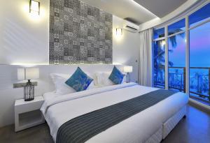 马富施Velana Beach Hotel Maldives的白色的卧室设有一张大床和一个窗户