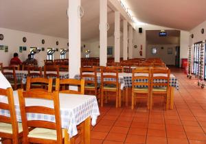 Malhadinhas帕尔克森林度假酒店的用餐室配有木桌和椅子