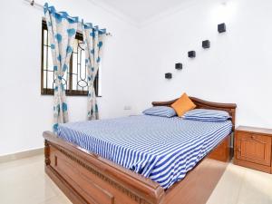 卡兰古特Esha Apartment的一间卧室配有一张带蓝色和白色棉被的床