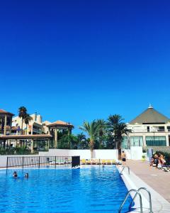 阿罗纳Apartamento en Playa Las Vistas - Torres del Sol的和水中的人在度假村的游泳池