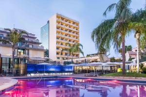 马略卡岛帕尔马艾斯拉马略卡酒店&温泉的大楼前有游泳池的酒店