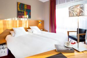 Carspach欧布尔森多为恩酒店的卧室配有白色的床和桌椅