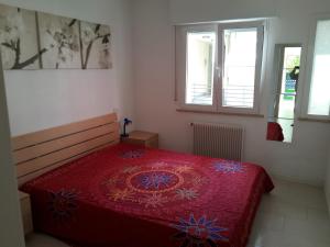格拉多Villa Flora的一间卧室设有红色的床和2个窗户