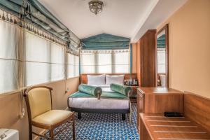 博尔若米博尔若米金色郁金香酒店的一间卧室配有一张床、一张桌子和一把椅子