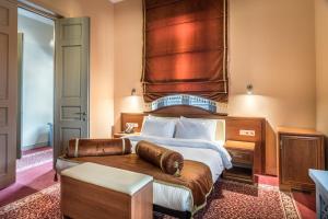 博尔若米博尔若米金色郁金香酒店的一间卧室配有一张大床和木制床头板