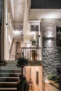 约阿尼纳羽衣甘蓝精品旅馆的大堂设有楼梯和石墙