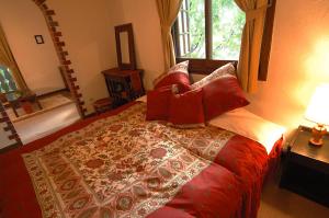 白马村贝尔妮娜山林小屋的一间卧室配有一张带红色枕头的大床