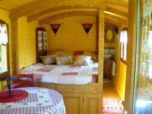 普吕维涅克雷拖车假日公园的巴士上的卧室,里面设有一张床