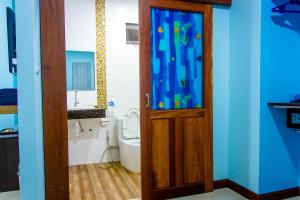 高兰i-Style Lanta Boutique House --- SHA Extra Plus的一间带卫生间和木门的浴室