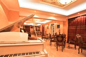 乌兰巴托白屋酒店的一间设有钢琴和桌椅的餐厅