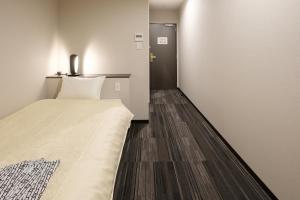 泉佐野瑞库高级酒店的小房间,设有床和门