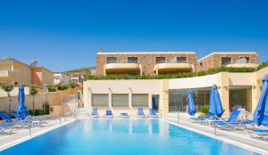 卡法斯爱琴海之梦酒店的一个带椅子和蓝伞的游泳池