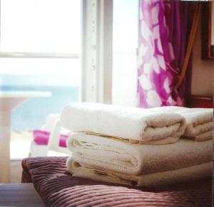 马斯蒂查里Sea Breeze Hotel的床上的一大堆毛巾