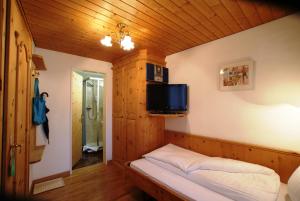 施库尔爱斯酒店的小房间设有一张床和墙上的电视