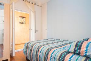 锡切斯桑尼公寓的一间卧室配有带条纹被子的床