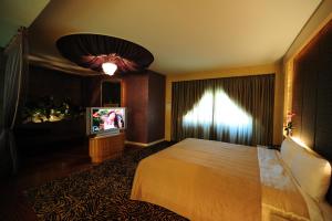 新竹金座渡假汽车旅馆的酒店客房,配有床和电视