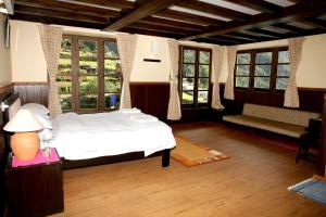 MonjoMountain Lodges of Nepal - Monjo的一间卧室配有一张床、一张沙发和窗户。