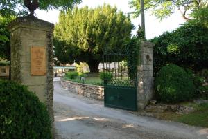 罗卡马杜尔Belveyre à Rocamadour的通往带石墙的花园的大门