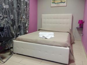 卡塞勒托瑞尼斯尼亚加拉酒店的一间小卧室,配有一张白色的床和椅子