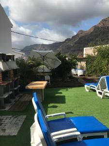 法塔加加那利伊利莎酒店的庭院配有桌椅和遮阳伞。