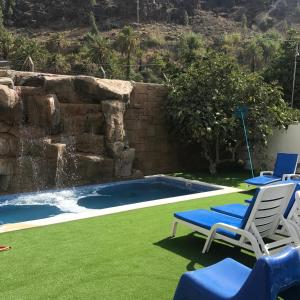 法塔加加那利伊利莎酒店的后院设有带椅子和瀑布的游泳池