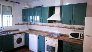 埃尔博斯克Casa La Vega的厨房配有绿色橱柜、洗衣机和烘干机
