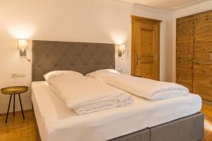 乌登斯Sportchalet Zillertal的一间卧室配有两张带白色枕头的床