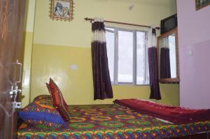 瓦拉纳西阿祖尔旅馆的一间卧室设有一张床和一个窗口