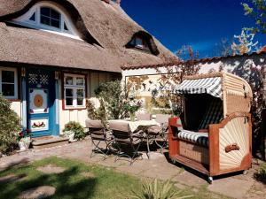 普雷罗Haus am Hafen - romantisch unter Reet, Garten mit Strandkorb und Terrasse的坐在房子外的大柳条椅