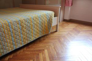 米兰米勒利尔如家公寓的一间卧室配有一张床,铺有木地板