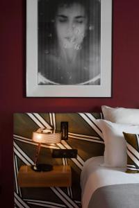 巴黎皮埃蒙特卢浮宫酒店的一间卧室配有照片和床头灯