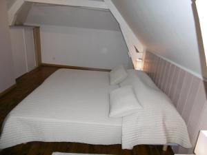 希农Le petit domaine des Aubuis的一张带两个枕头的小白色床