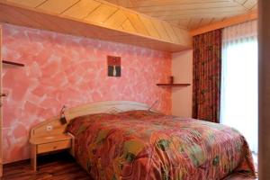 戈尔德格雷特梅各生物旅馆的一间卧室配有一张床和粉红色的墙壁