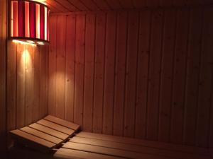 普雷斯科普Le Clos du Gusquel的墙上有灯光的木制桑拿浴室