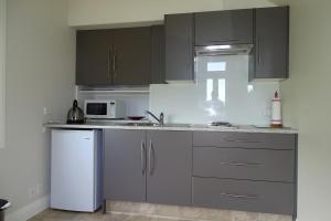 布伦海姆Korohi Vineyard BnB的厨房配有灰色橱柜和白色冰箱