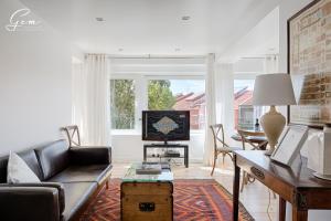 里斯本七河豪华公寓 的客厅配有沙发和桌子
