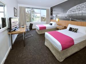 墨尔本北墨尔本美居酒店的酒店客房配有两张床和一张书桌