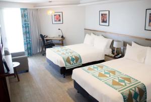 苏瓦苏瓦假日酒店的酒店客房配有两张床和一张书桌