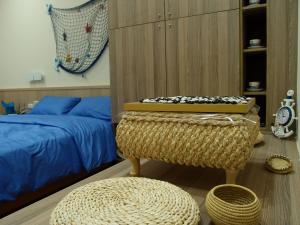 台南基石民宿 的一间卧室配有一张床、两张搁脚凳和一张卧床。