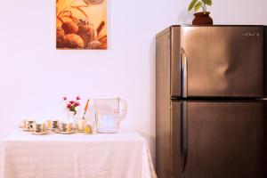 贾夫纳迪维拉旅馆的厨房配有冰箱,旁边是桌子和桌子