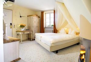 拜罗伊特鲁目勒餐厅酒店的一间卧室配有一张天蓬床和一张书桌
