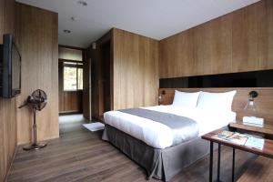 和平区台中商务旅馆－八仙山庄 的一间卧室配有一张床、一张书桌和一台电视